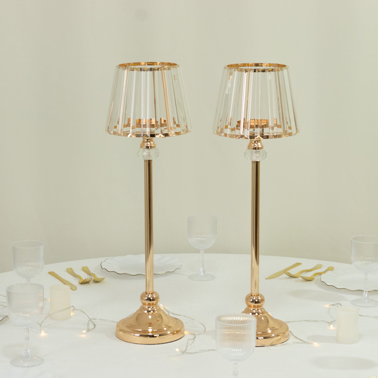 Gold crystal pendant candle holders for elegant table centerpieces.
