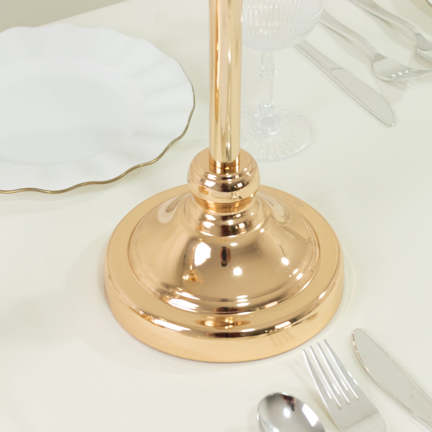 Gold crystal pendant candle holder base on a table setting.
