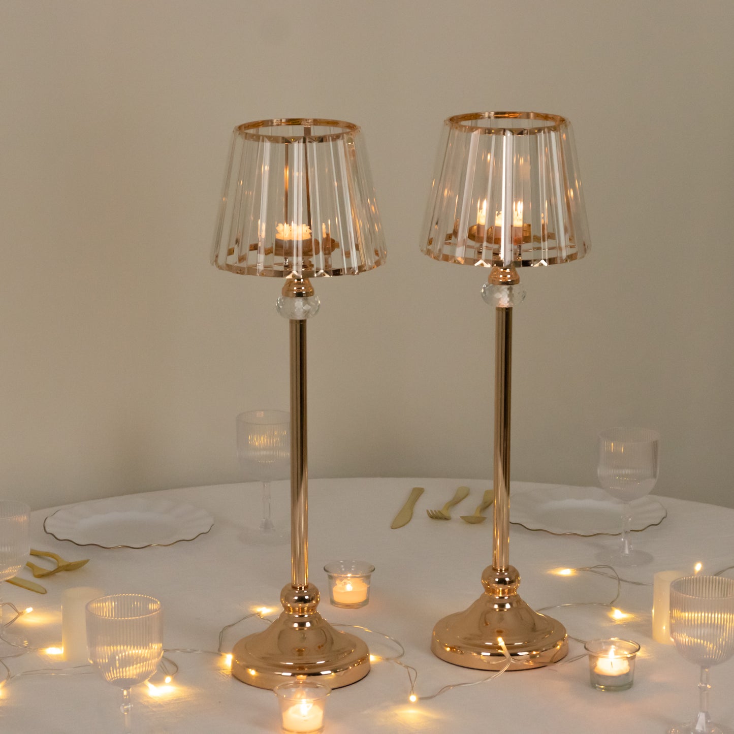 Gold crystal pendant candle holders for elegant table centerpieces.