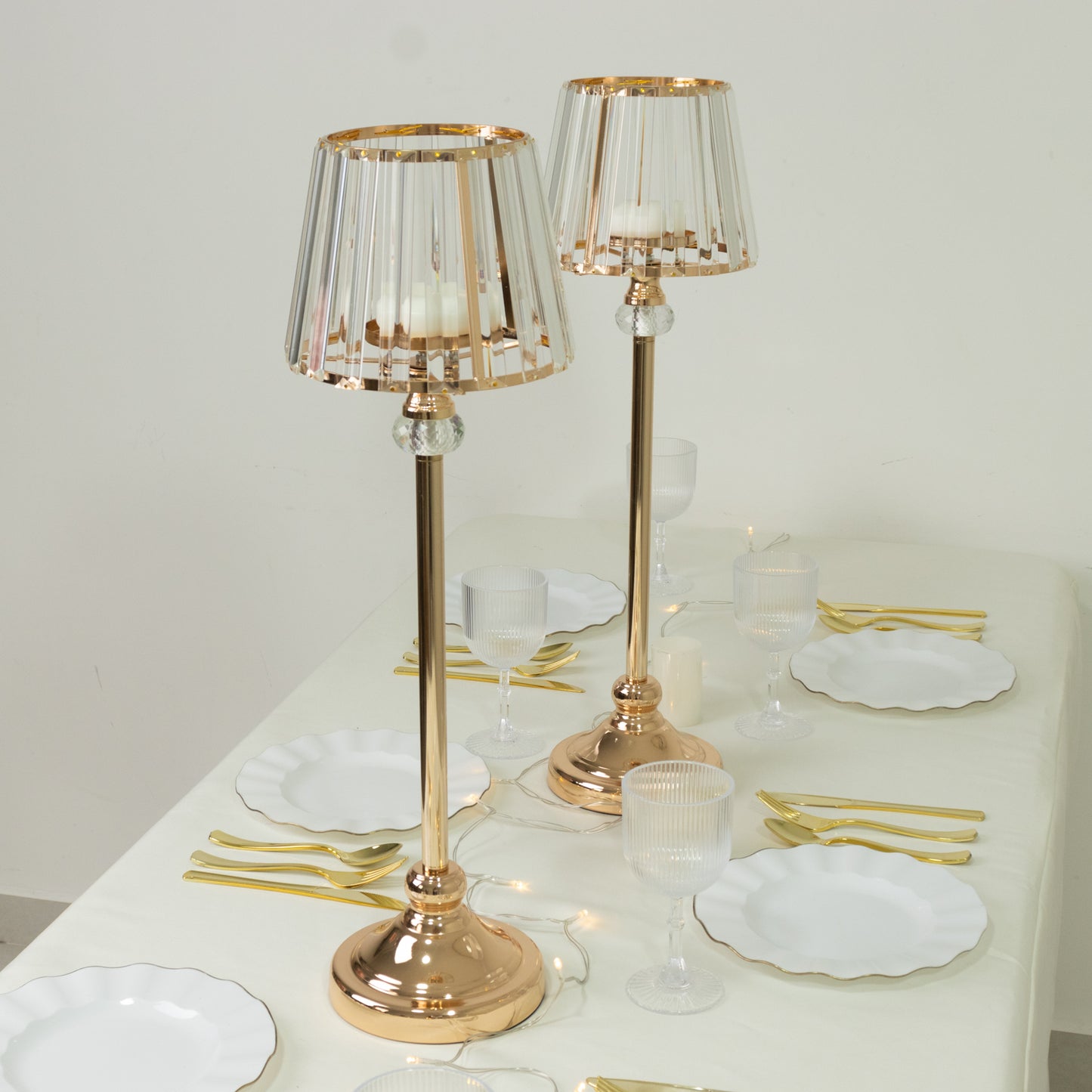 Gold crystal pendant candle holders for elegant table centerpieces.