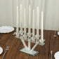 Clear crystal candelabra with 7 branches holding taper candles on a mirrored base.