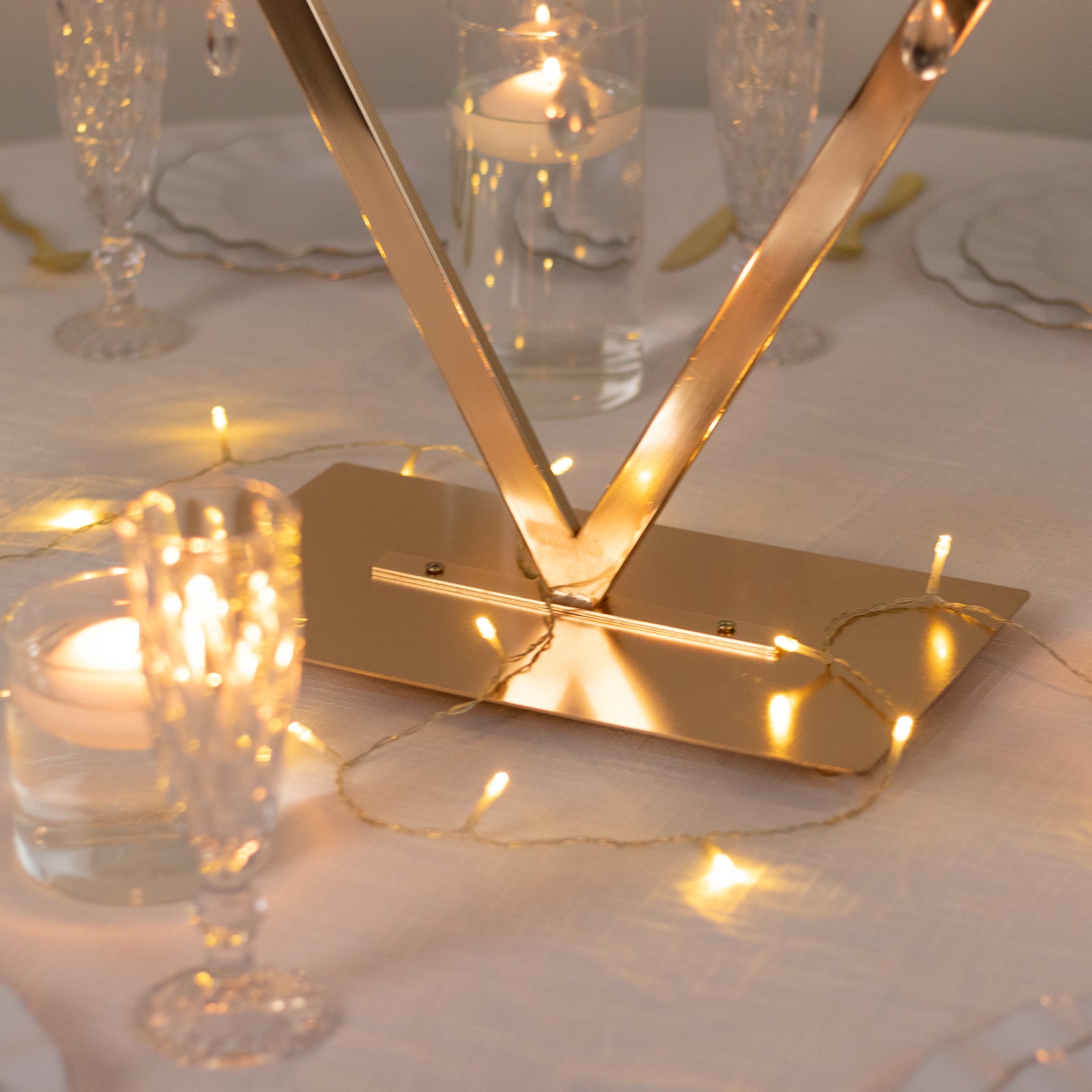 Gold acrylic candelabra centerpiece with candle holders and sparkling lights.