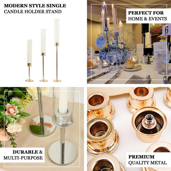 Gold metal candlestick holders with clear glass shades for elegant decor.