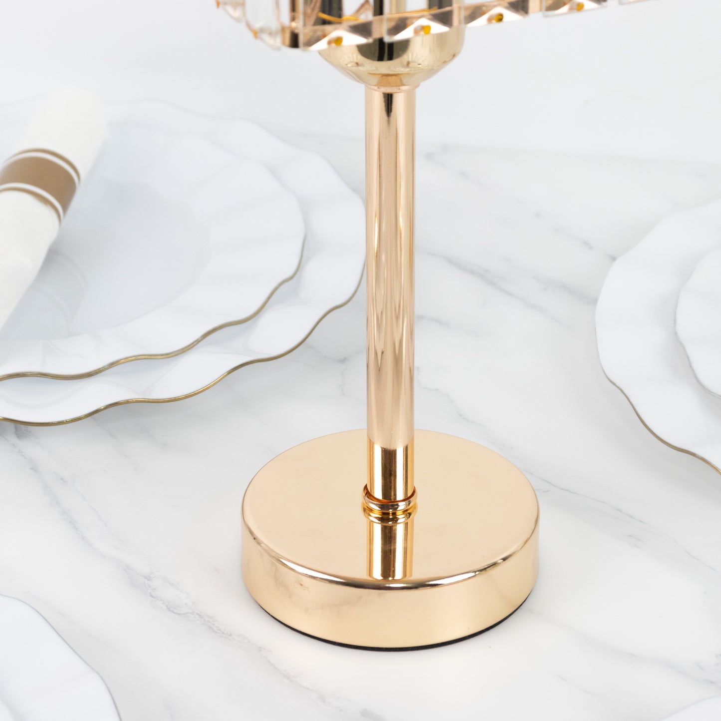 Gold crystal hurricane candle holder on a marble surface.