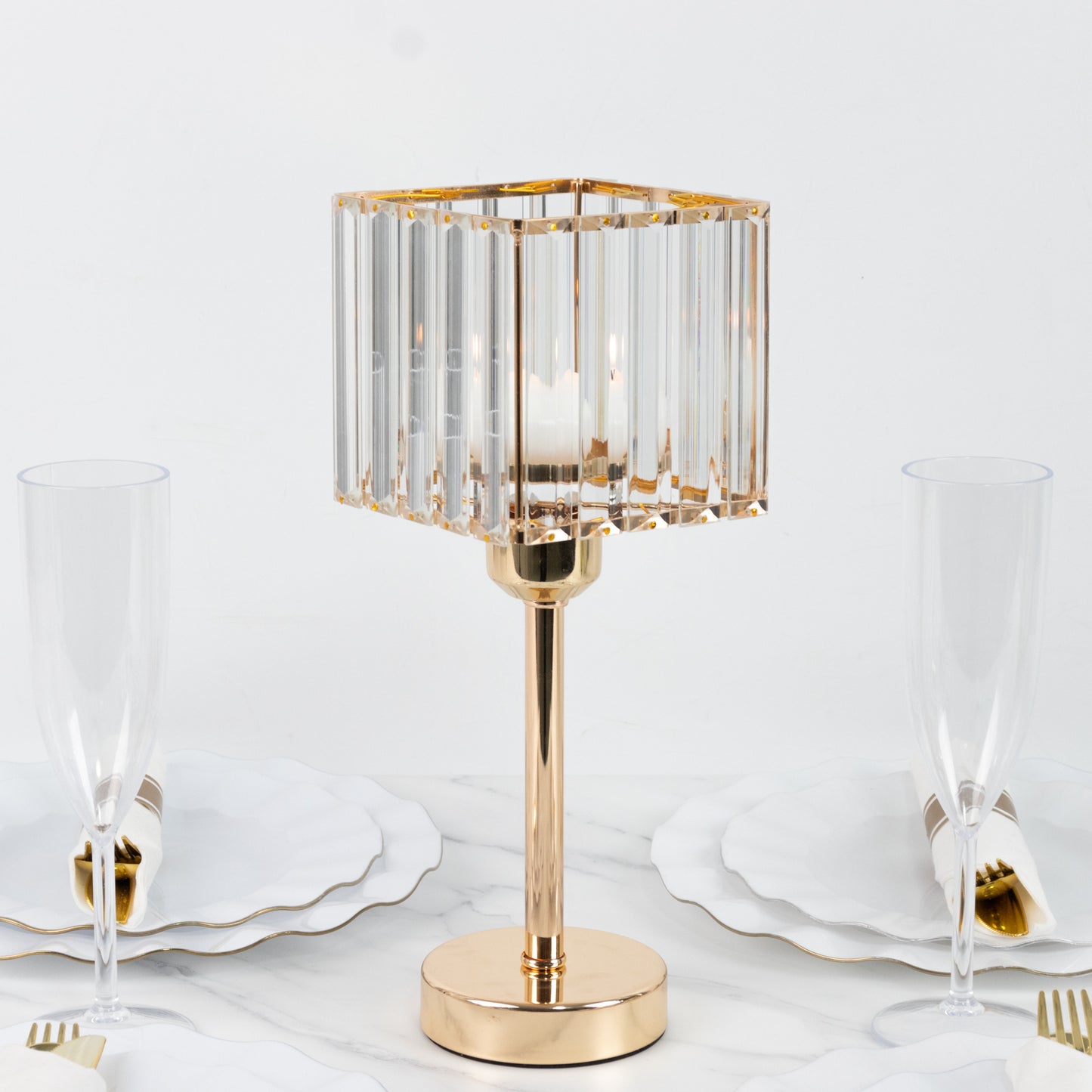 Gold crystal hurricane candle holder on a dining table setting.