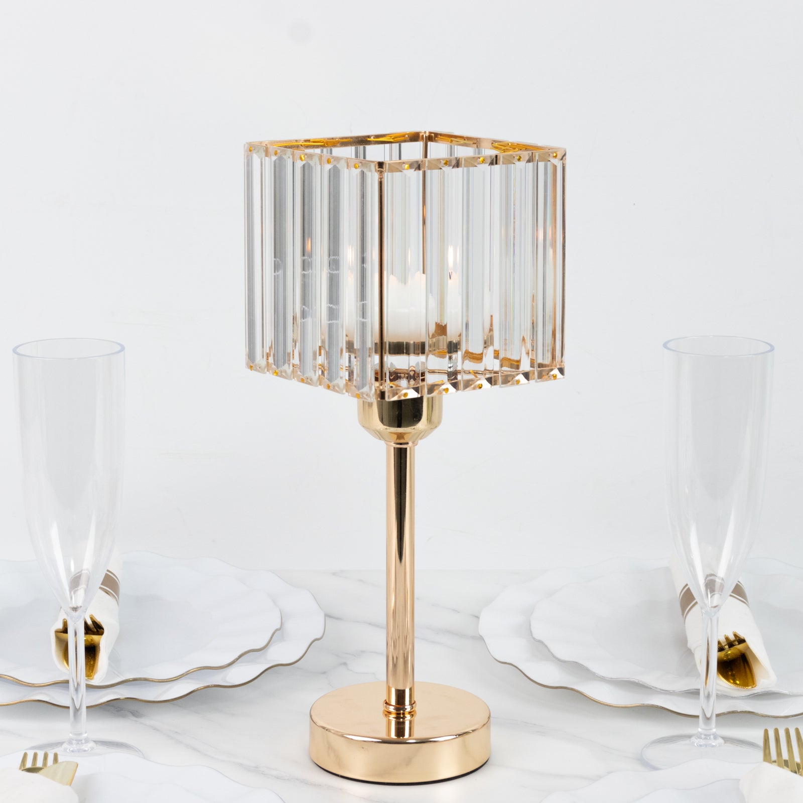 Gold crystal hurricane candle holder on a dining table setting.