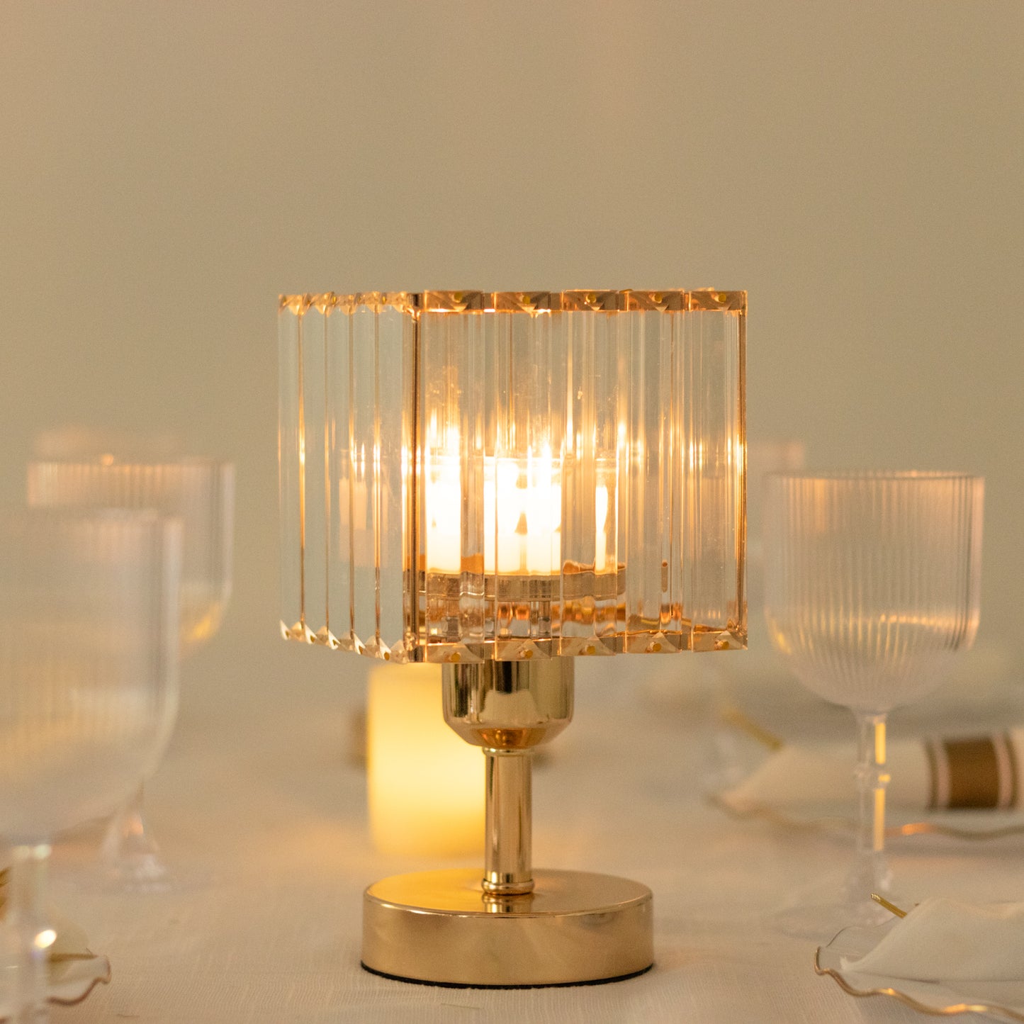 Gold crystal hurricane candle holder centerpiece with pillar candles.