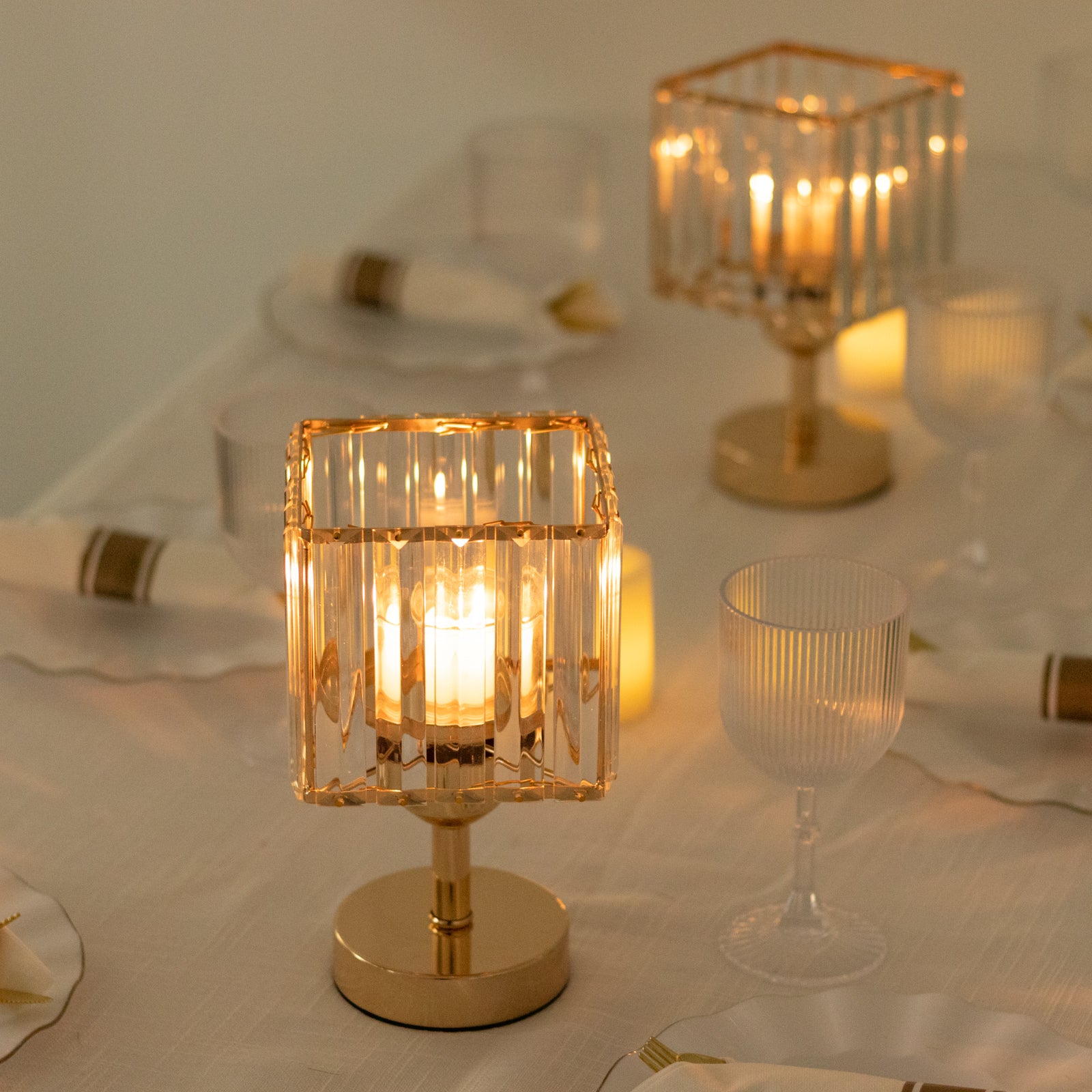 Gold crystal pendant candle holders for elegant table centerpieces.