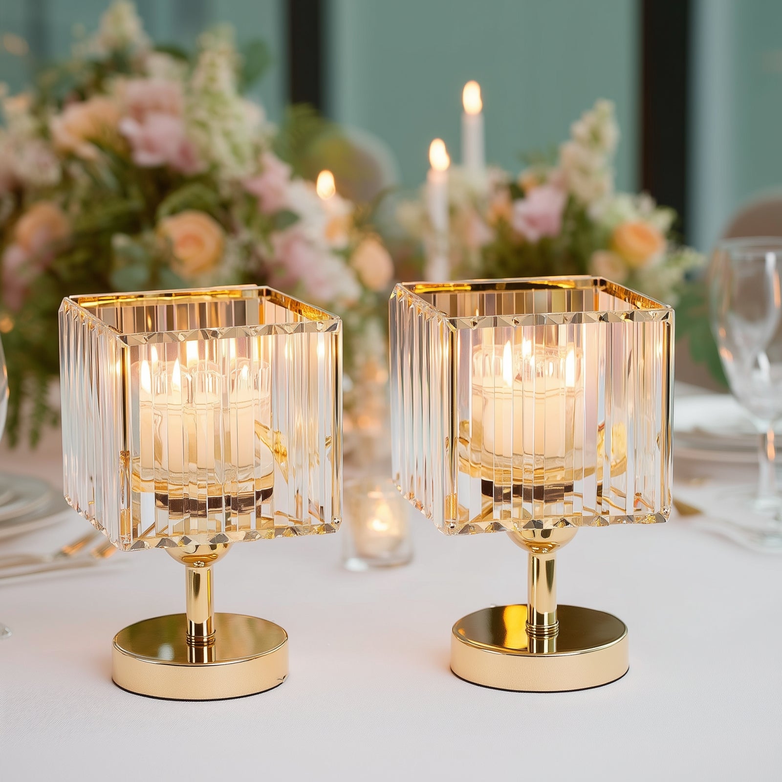 Gold crystal pendant hurricane candle holders as elegant table centerpieces.