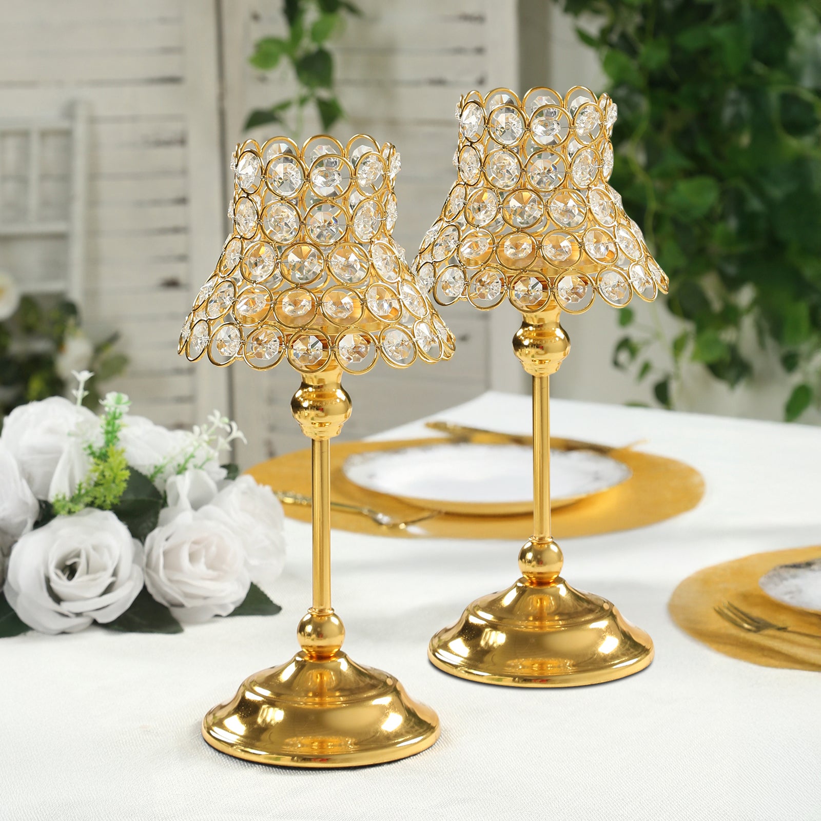 Gold beaded candle holders with lamp-inspired shades for elegant table decor.