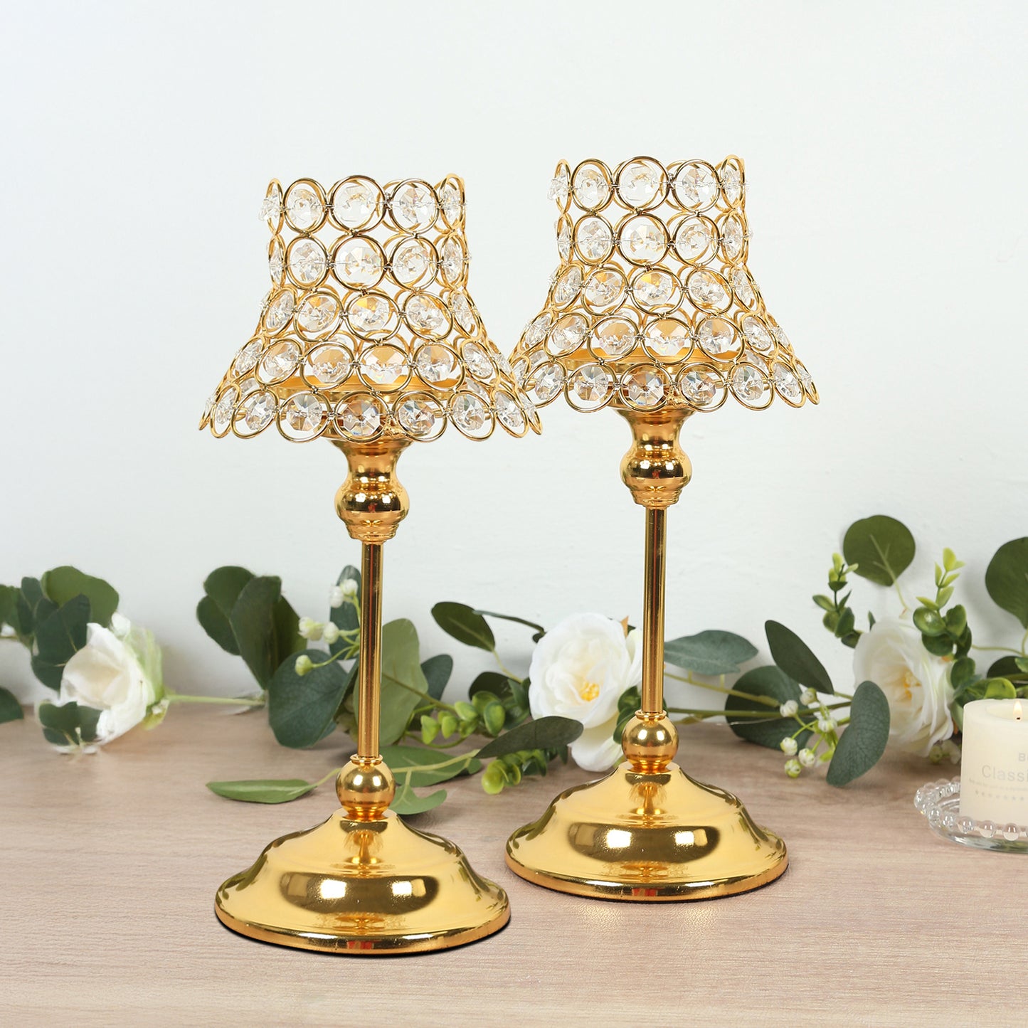 Gold crystal beaded candle holders with lamp-inspired shades for elegant table decor.