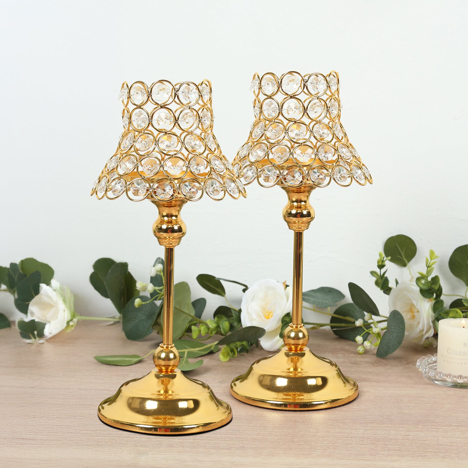 Gold crystal beaded candle holders with lamp-inspired shades for elegant table decor.
