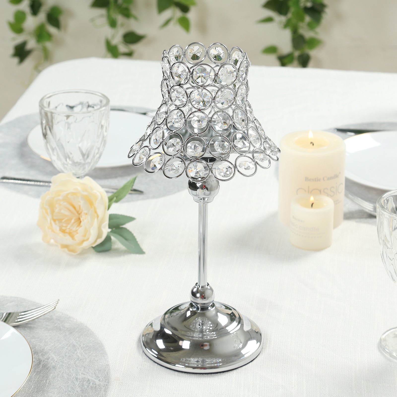 Silver beaded candle holder with lamp-inspired shade for elegant table settings.