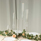 Clear acrylic hurricane candle stands with tall chimney shades, elegant table decor.