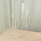 Clear acrylic hurricane candle stands with tall chimneys in various heights.