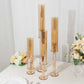Amber gold hurricane candle holders set of 4 on a table.