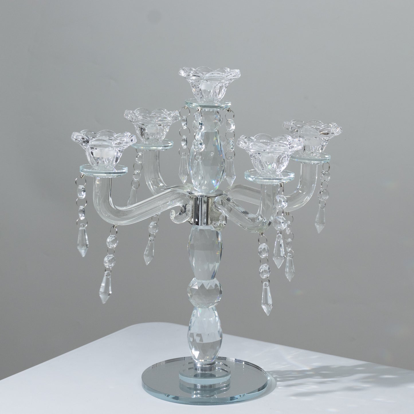 Elegant crystal taper candle holder with 5 arms and hanging pendants.