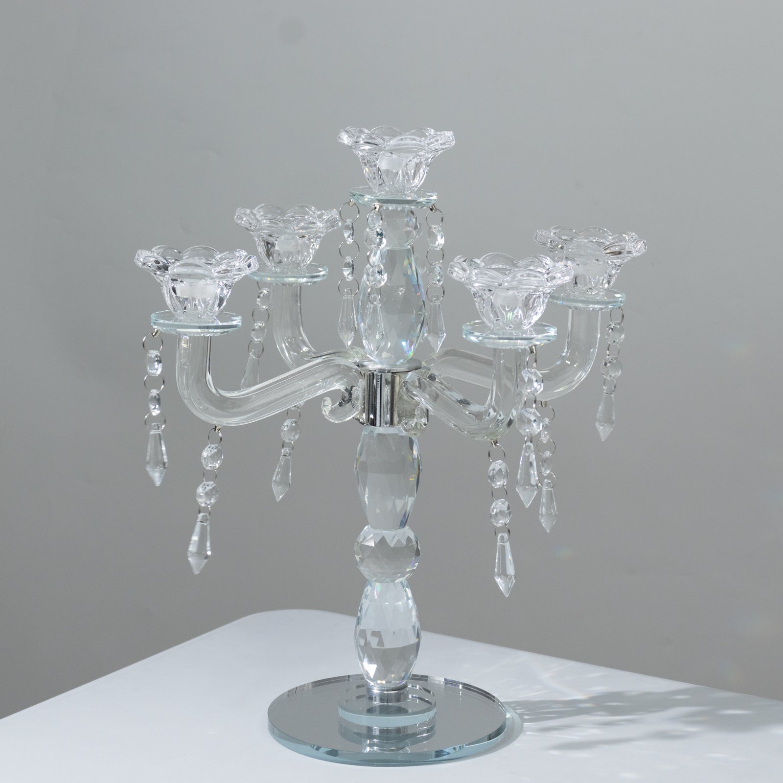 Elegant crystal taper candle holder with 5 arms and hanging pendants.
