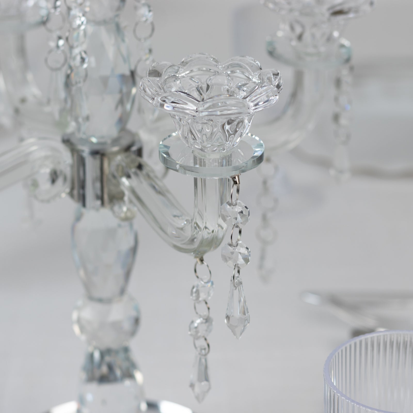 Clear crystal taper candle holder with five arms and elegant hanging pendants.