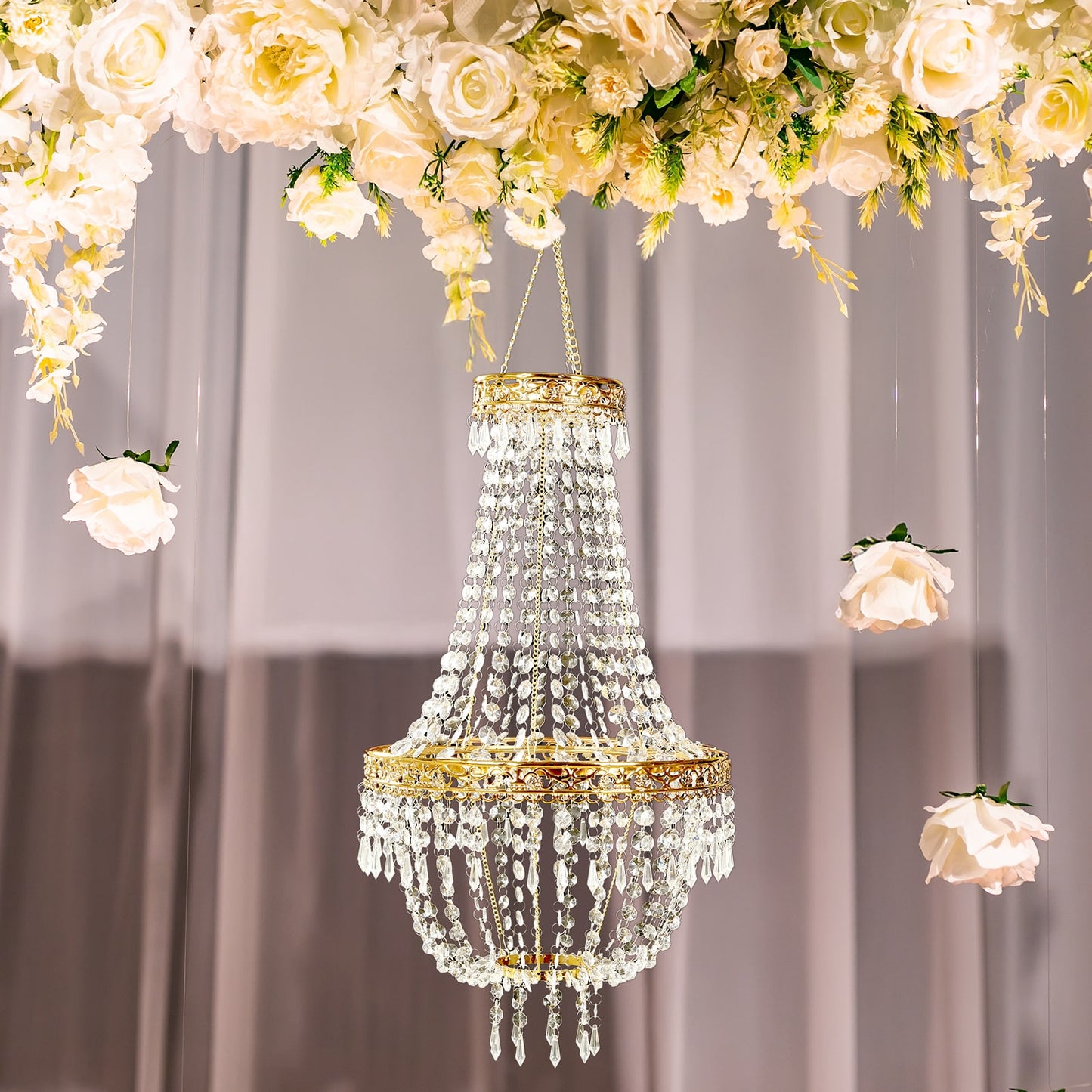 Gold beaded crystal chandelier with ornate metal frame and floral backdrop.