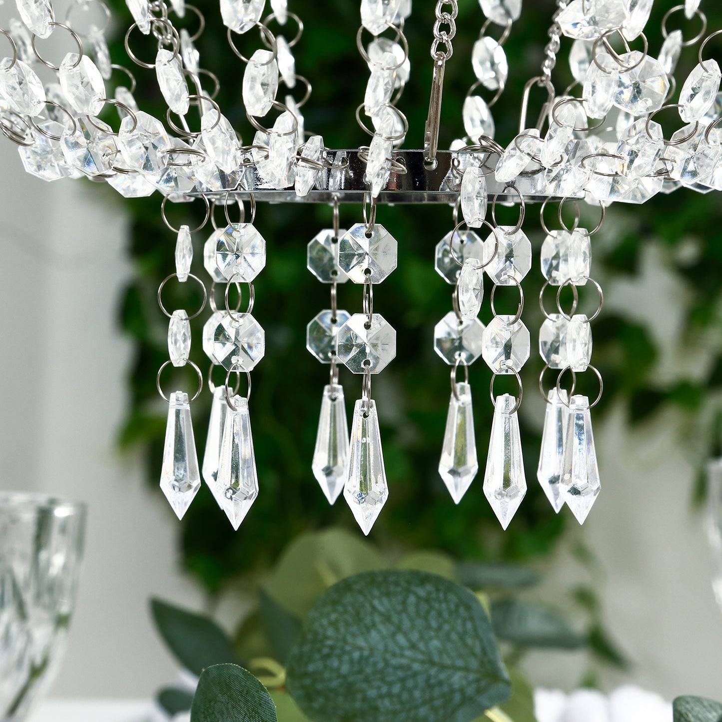 Silver beaded crystal chandelier with ornate metal frame.