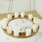 Gold hanging metal floral chandelier frame with candles and floral display.