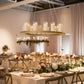 Gold chandelier frame with candles and floral display in an elegant setting.