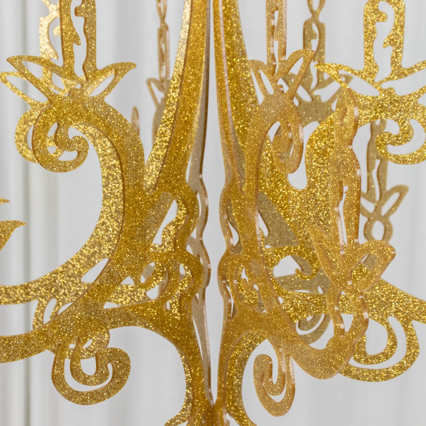 Gold glittered acrylic chandelier decor with 3D interlocking design.