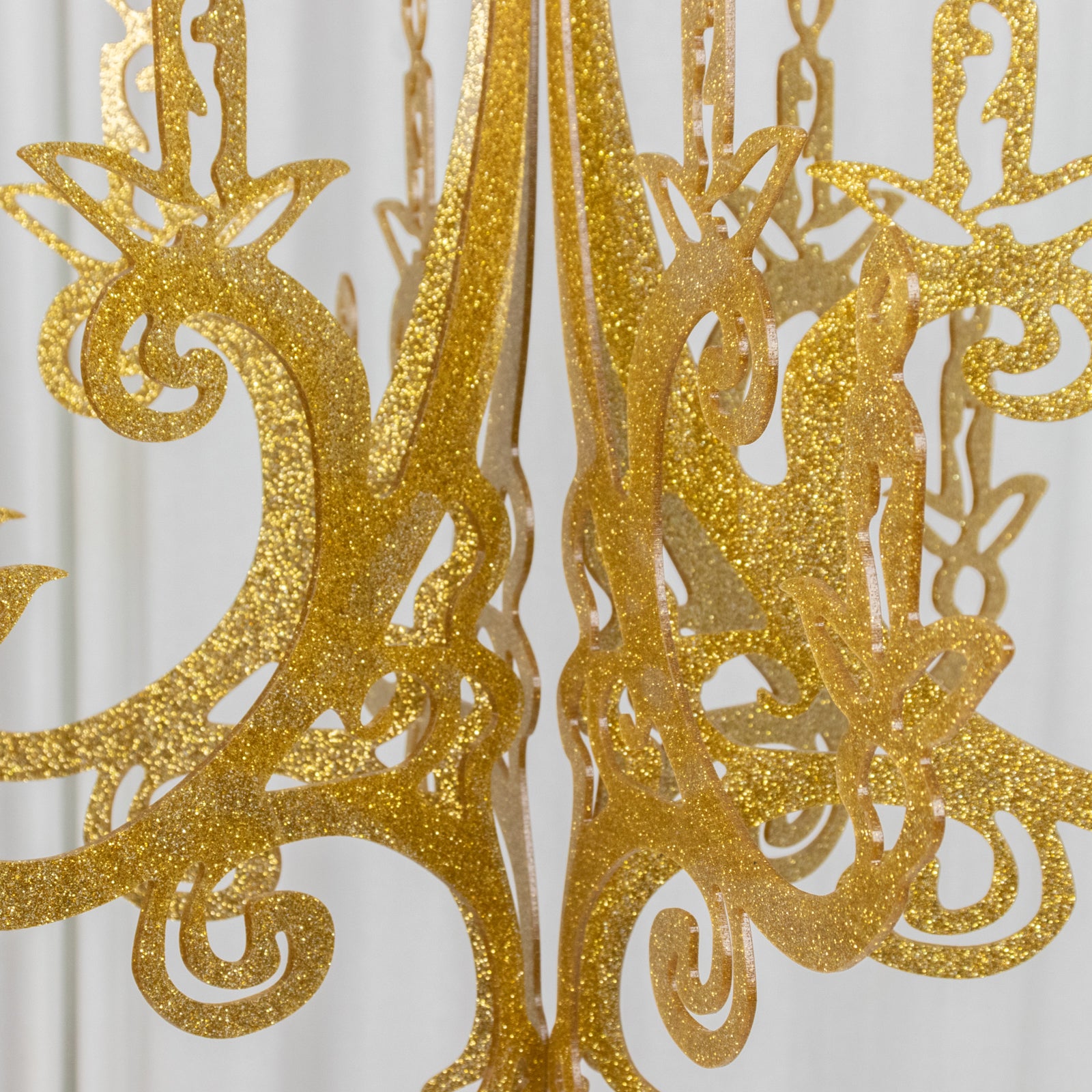 Gold glittered acrylic chandelier decor with 3D interlocking design.