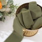 Dusty sage green chiffon ribbon roll in a decorative bowl.