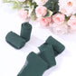 Hunter emerald green chiffon ribbon rolls with pink roses in the background.