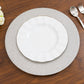 Silver glitter round charger plates on a wooden table setting.