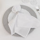 Silver dust-free glitter acrylic round charger plate with a white napkin.