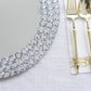 Silver charger plates with diamond beaded rim on a white table setting.
