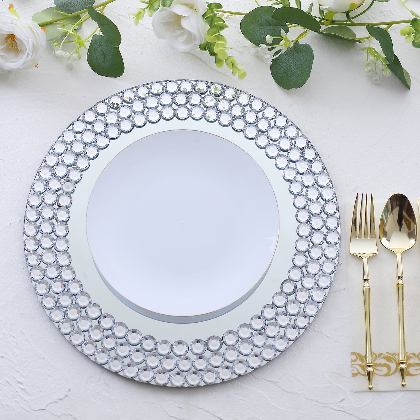 Silver round mirror glass charger plate with diamond beaded rim.