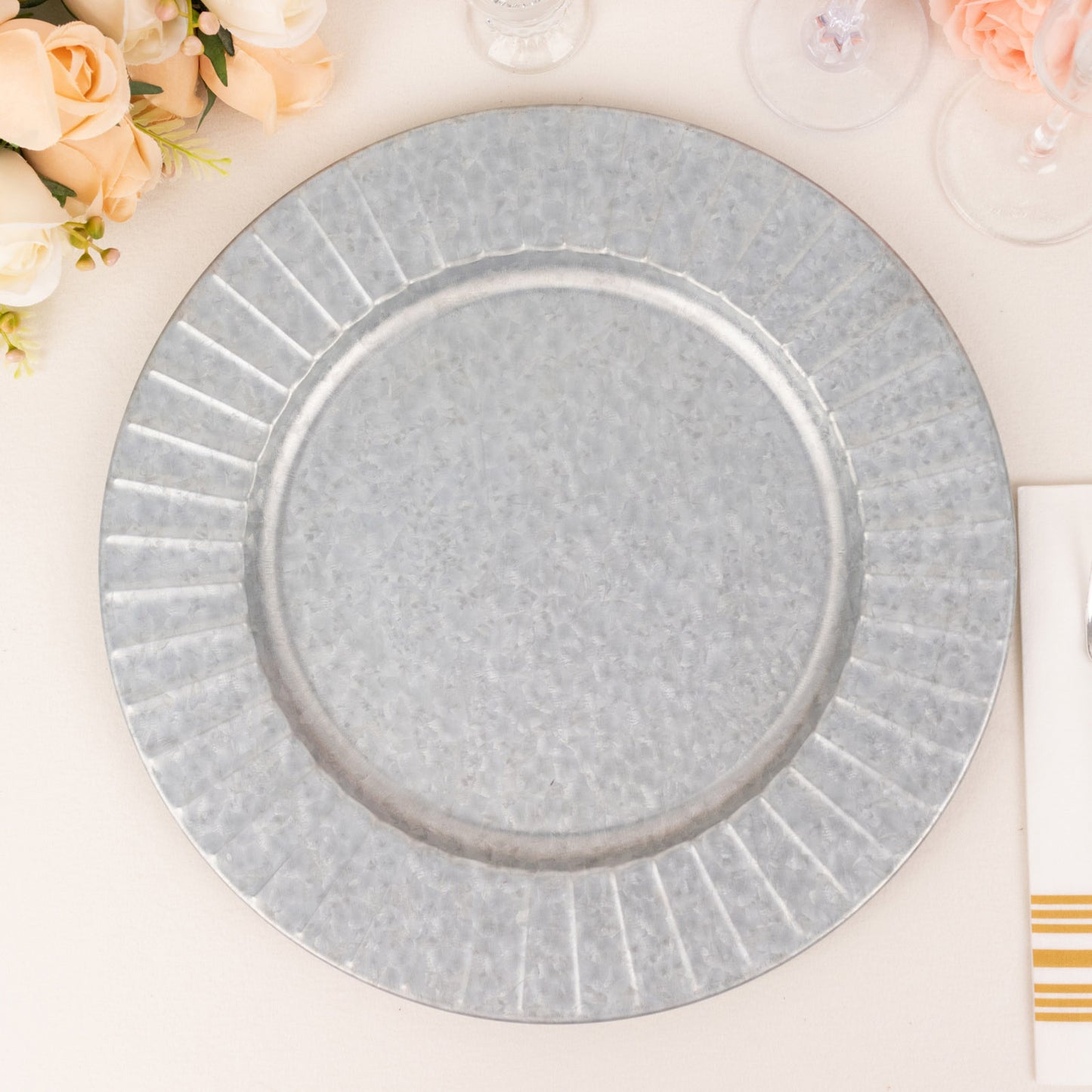 Silver galvanized metal charger plate with ruffled rim.