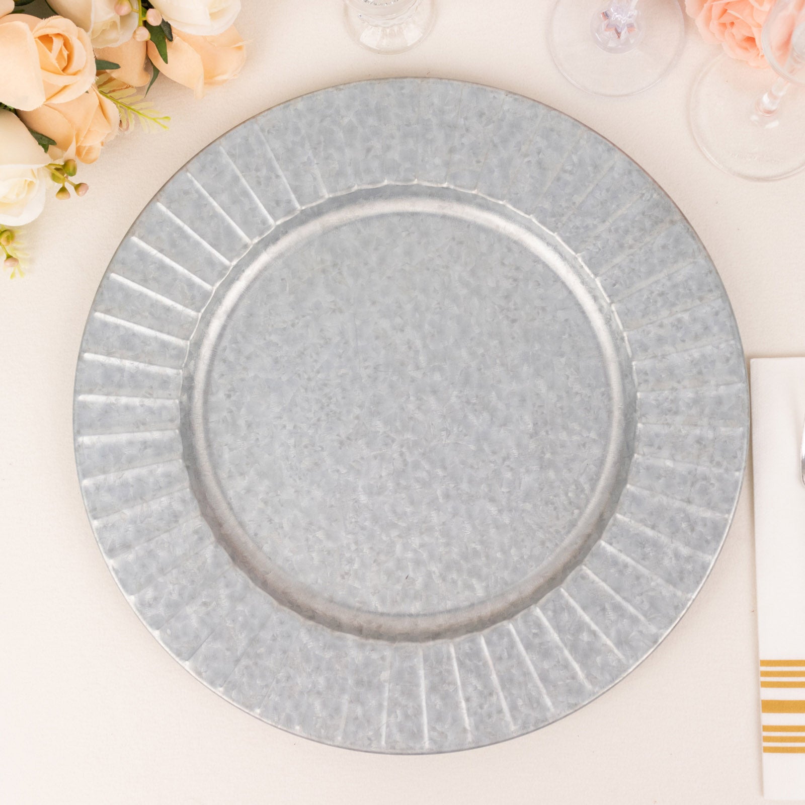 Silver galvanized metal charger plate with ruffled rim.