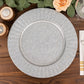 Silver galvanized metal charger plate with ruffled rim on a wooden table.