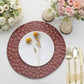 Burgundy hammered charger plate with white dinner plate and floral decor.