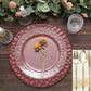Matte finish burgundy hammered charger plate with a floral accent.