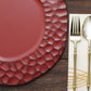Burgundy hammered charger plate with a matte finish on a wooden table.