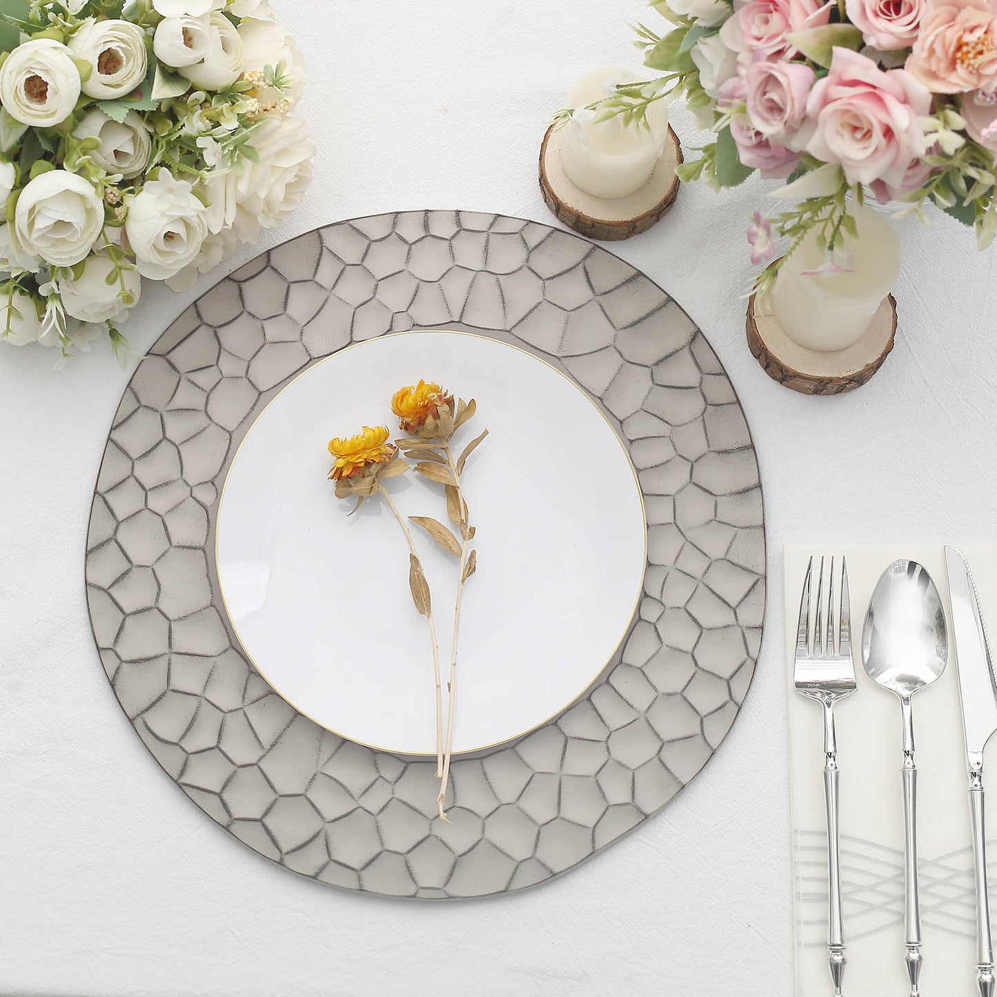Matte gray hammered charger plate with white dinner plate and flowers.