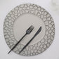 Matte finish gray hammered charger plate with black utensils.