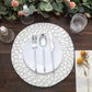 Elegant white dinnerware set on a textured placemat with candles and floral decor.