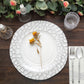 Elegant white dinner plate with floral accent, set on a rustic wooden table.