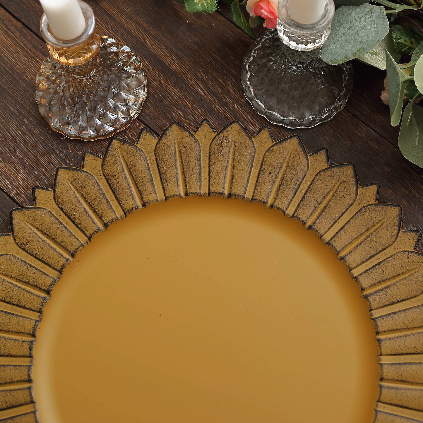 Matte mustard yellow sunflower disposable charger plate on a wooden table.