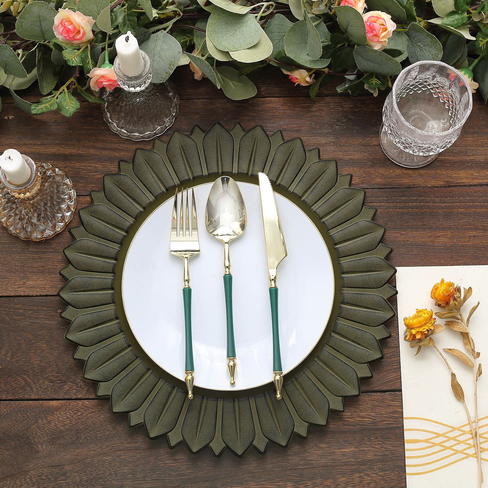 13" Matte Olive Green Sunflower Disposable Charger Plate with utensils on a rustic table.