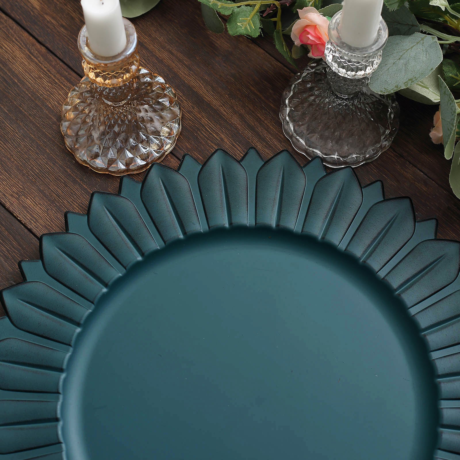Matte teal sunflower disposable charger plate on a wooden surface.