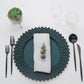 Matte teal sunflower disposable charger plate with a napkin and greenery.