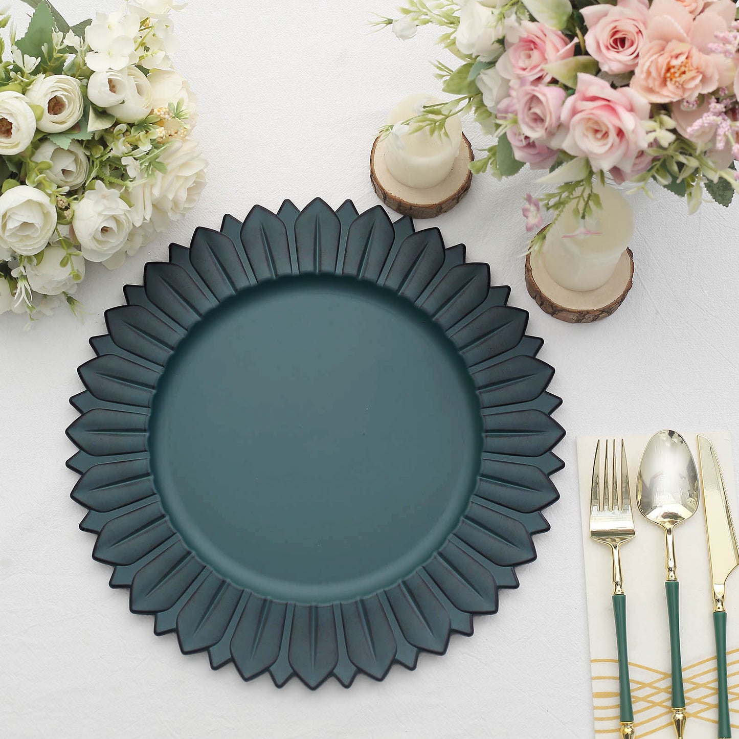 Matte teal sunflower charger plate on a table with flowers and cutlery.